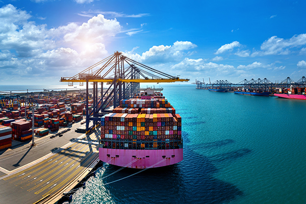 Aerial view of cargo ship and cargo container in harbor.